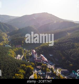Veduta aerea di una piccola città nel territorio di Altai. Vista dall'alto della cittadina di Belokurikha. Vista dall'alto delle case tra le foreste sul Foto Stock
