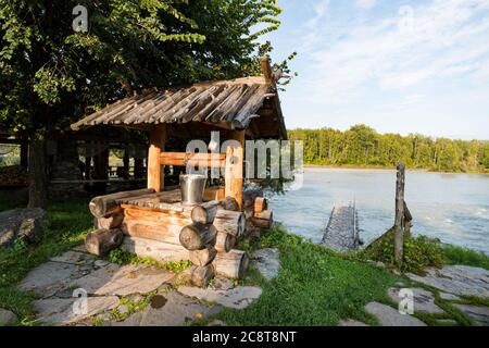 Pozzo tradizionale nel villaggio sulla riva del fiume. Acqua vecchio pozzo di legno, vecchia pompa dell'acqua Foto Stock