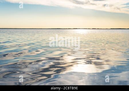 raggi solari riflessi sull'acqua di mare. Abbagliare l'acqua sotto forma di stelle. Naturale astratto mare acqua di fondo. Foto Stock