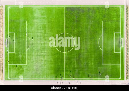 vista dall'alto del campo da calcio, del campo da calcio. i giocatori di calcio giocano sul prato falciato dello stadio. vista aerea del campo da calcio reale Foto Stock