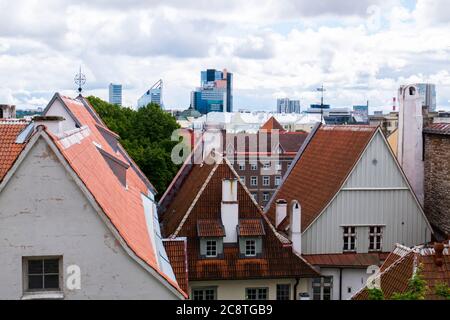 La giustapposizione dei classici tetti arancioni della Citta' Vecchia con i moderni edifici di uffici in vetro in lontananza. A Tallinn, Estonia. Foto Stock