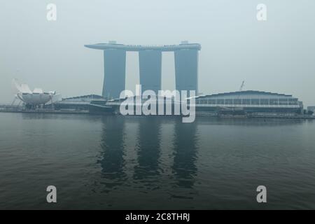 Architettura di Marina Bay Sands coperto da inquinamento atmosferico dalla deforestazione in Indonesia. Singapore, Sud-est asiatico, Foto Stock