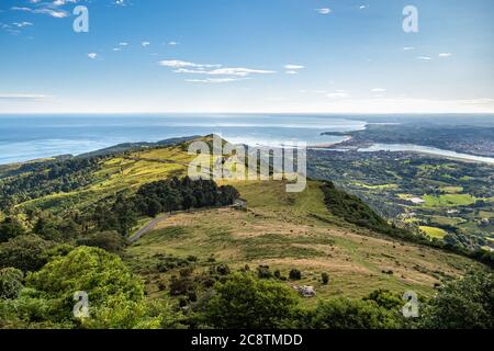 Vista panoramica di verde collina, mare e città e confine tra Spagna e Francia. Paesi Baschi la mattina presto. Foto Stock