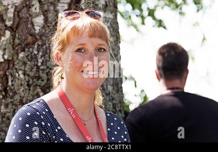 Umea, Norrland Svezia - 5 giugno 2020: Donna frettolata nel parco con sorriso Foto Stock