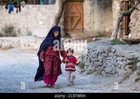 Donna musulmana con bambino in abiti colorati dal villaggio di montagna Foto Stock