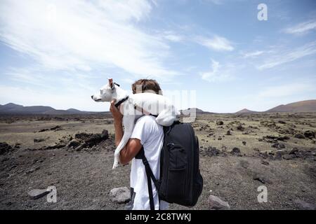 Cane e il suo proprietario a piedi sulla rotta del vulcano a Lanzarote Foto Stock