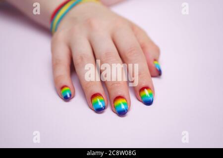 Foto della mano della donna con unghie arcobaleno Foto Stock