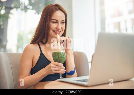 Donna sorridente che guarda lo schermo del laptop Foto Stock