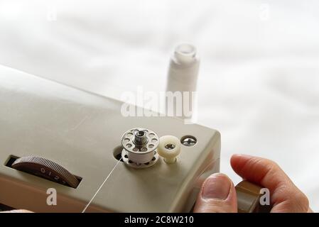 mani di un filo di avvolgimento di marinai da una bobina ad una bobina, primo piano. Foto Stock