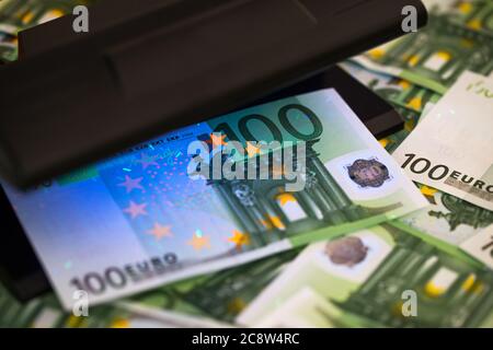 Controllo autenticazione banconote in euro in luci uv, concetto finanziario e bancario Foto Stock