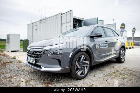 Elsfarth, Germania. 23 luglio 2020. Un'auto alimentata a idrogeno è in piedi davanti all'attrezzatura tecnica dell'elettrolizzatore di un impianto di produzione di idrogeno di PECORA nel distretto di Huntorf. Credit: Hauke-Christian Dittrich/dpa/Alamy Live News Foto Stock
