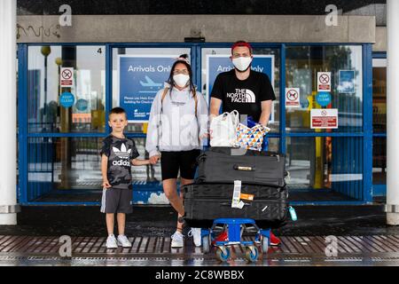 Christopher Andres Halliday con il suo partner Melissa Campbell e il loro figlio di sei anni, Lewis Andres, che vive a Belfast lasciando Belfast International Airport dopo essere arrivato su Easyjet 10 EJU6672 volo da Barcellona, Spagna. L'esecutivo dell'Irlanda del Nord è destinato a riunirsi più tardi per discutere una decisione di introdurre la quarantena per coloro che arrivano nella regione dalla Spagna. Foto Stock