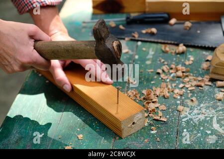 Falegname con martello che colpisce nails.Woodwork concetto. Foto Stock