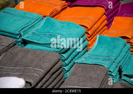 asciugamani di colore diverso su pila per la vendita Foto Stock
