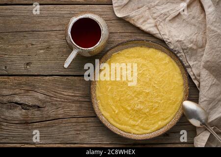 polenta porridge con tè della tazza, sfondo di legno scuro, spazio di copia vista dall'alto Foto Stock