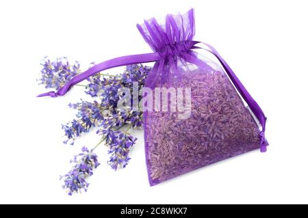 Profumo di fiori estivi, omaggio naturista rilassante e concetto di profumo floreale con lavanda secca in una borsa di stoffa viola accanto a fiori viola freschi Foto Stock
