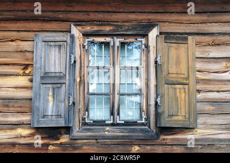 Una finestra con copertura in una vecchia casa di campagna. Pareti di casa in legno naturale con una finestra. Foto Stock