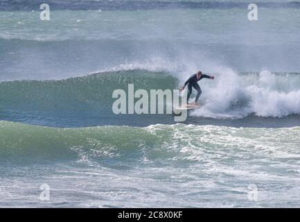 Garrettstown, Cork, Irlanda. 27 luglio, 2020.A surfer cavalca l'onda in tempesta turbolenta come le condizioni a Garrettstown, Co. Cork, Irlanda. - credito; David Creedon / Alamy Live News Foto Stock