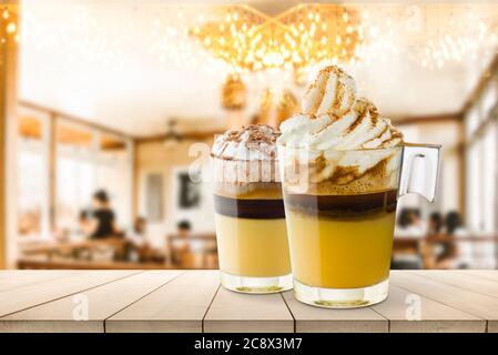 Tazze di panna di caffè su un tavolo di legno nella caffetteria. Foto Stock