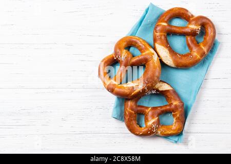 Pretzel freschi sul retro su un asciugamano blu, spuntino di birra, vista dall'alto con spazio per le copie Foto Stock