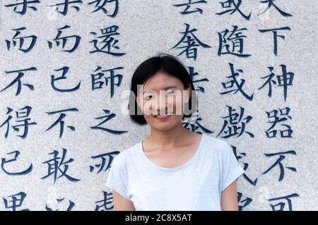 Una donna cinese che si trova di fronte agli insegnamenti di Laozhi, la creatrice del taoismo all'interno della zona panoramica del Palazzo di Taiqing a Qingdao China Shandong pro Foto Stock