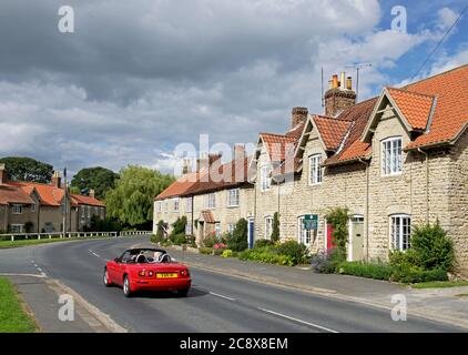 Mazda MX5 auto sportiva nel villaggio di Hovingham, Ryedale, North Yorkshire, Inghilterra Regno Unito Foto Stock