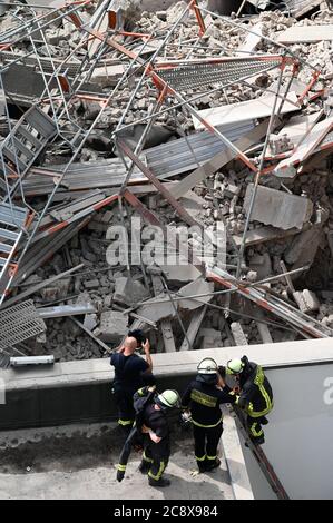 Duesseldorf, Germania. 27 luglio 2020. I vigili del fuoco si trovano di fronte all'edificio e all'impalcatura. Nel centro di Düsseldorf, parti di un edificio sono crollate durante i lavori di costruzione. Una persona è mancante, ha detto un portavoce del reparto antincendio lunedì. In loco sono presenti circa 50 vigili del fuoco. La scena dell'incidente è in un edificio posteriore. (A dpa: 'Parti di un edificio a Duesseldorf crollato - una persona mancante') credito: Henning Kaiser/dpa/Alamy Live News Foto Stock