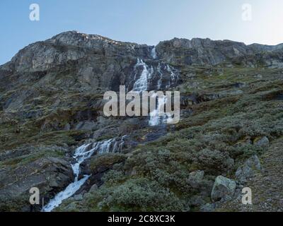 Cascata in montagna. Strada panoramica turistica nazionale 55 Sognefjellet tra Lom e Gaupne, Norvegia. Sfondo blu cielo. Foto Stock