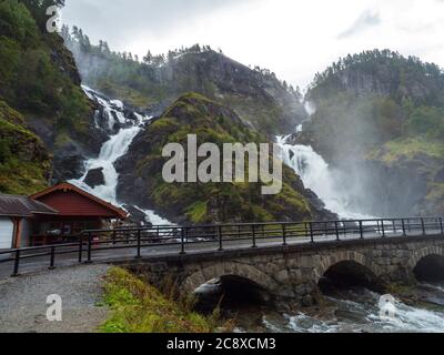 Doppia cascata Latefoss o Latefossen e sei ponti ad arco lungo la Route 13, Odda Hordaland County in Norvegia. Inizio autunno, cielo di luna Foto Stock
