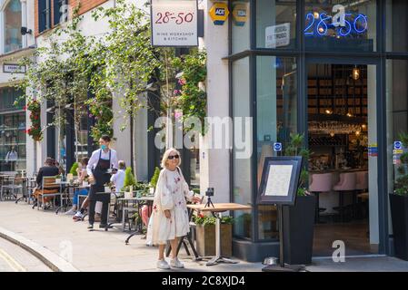 Le persone seduti ai tavoli da pranzo al fresco al 28-50 Wine Workshop e Kitchen Wine bar bistro, Marylebone Lane, Londra, Inghilterra, Regno Unito Foto Stock