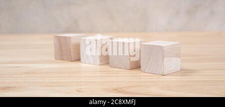 Cubetti giocattolo di legno su tavolo di legno e sfondo grigio Foto Stock
