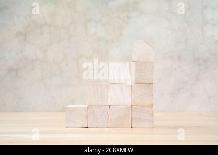 Cubetti giocattolo di legno su tavolo di legno e sfondo grigio Foto Stock
