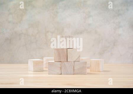 Cubetti giocattolo di legno su tavolo di legno e sfondo grigio Foto Stock
