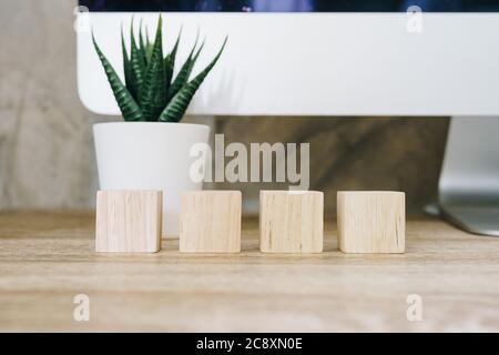 Quattro cubetti di legno giocattolo su sfondo tavolo di legno con spazio per la copia Foto Stock