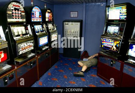 Dipendenza da gioco d'azzardo o dipendenza da gioco d'azzardo su una barca. Qualcuno che si addormentò tra le slot machine sul traghetto della compagnia di navigazione Scandline 'Trelleborg' in Germania. Foto Gippe Gustafsson Foto Stock