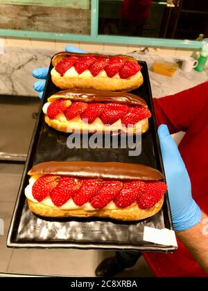 Strawberry Eclair con cioccolato servito in vassoio dallo chef al Patisserie. Foto Stock