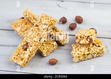 Barrette di muesli fatte in casa con noci arrostite, fuoco selettivo, sfondo in legno Foto Stock