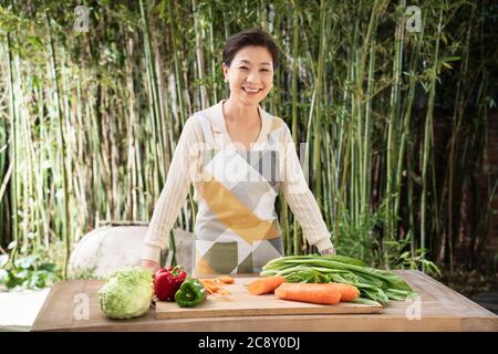 L'immagine del cortile delle donne di mezza età per preparare gli ingredienti Foto Stock