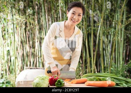 Il cortile tritare verdure in donne di mezza vita Foto Stock