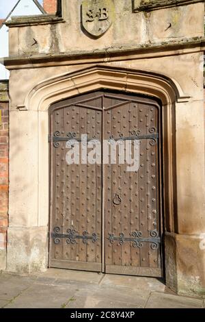 Porta in legno con chiodi e cornice in pietra. Foto Stock