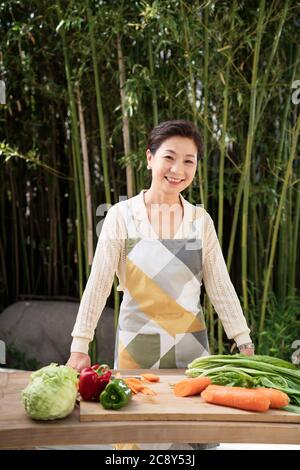 L'immagine del cortile delle donne di mezza età per preparare gli ingredienti Foto Stock