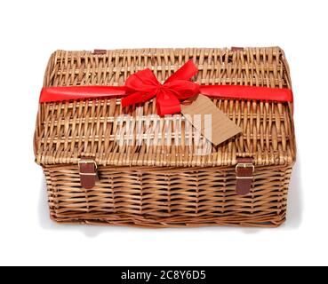 Un tradizionale cestino da picnic in vimini con un nastro rosso e arco. Foto Stock