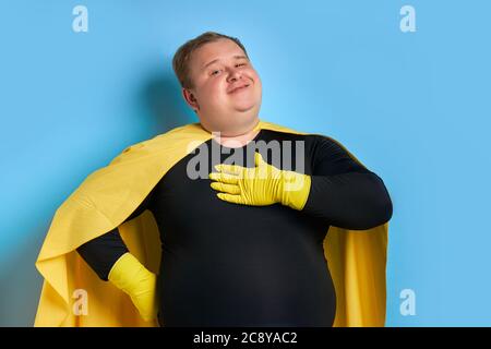ritratto di supereroe pulizia entusiasta isolato su sfondo blu. anatra gialla è un simbolo di bagno e pulizia. l'uomo è pronto per pulire Foto Stock