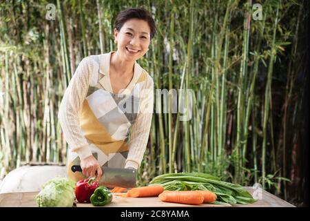 Il cortile tritare verdure in donne di mezza vita Foto Stock