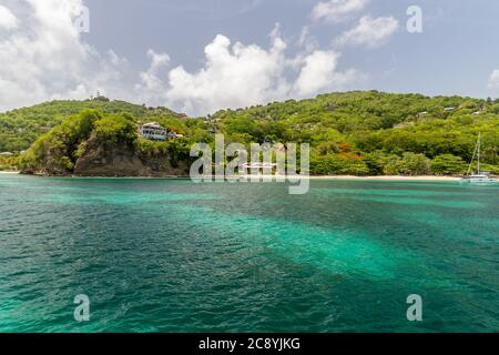 Acque turchesi nella baia di Admiralty con barche a vela e colline sullo sfondo, Bequia, Saint Vincent e Grenadine Foto Stock