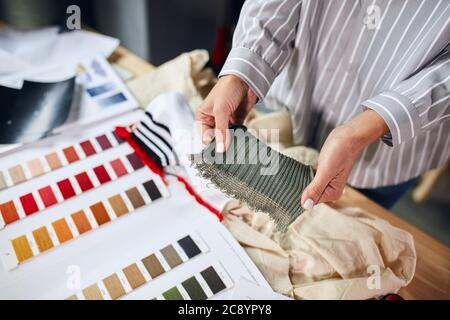 donna in camicia a righe scegliendo tessuto per vestiti.close up foto ritagliata Foto Stock