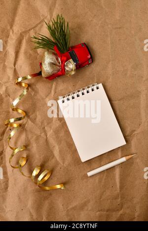 Il pick-up porta una borsa di regali, un albero di Natale, un taccuino vuoto, una matita bianca, composizione verticale, vista dall'alto. Foto Stock