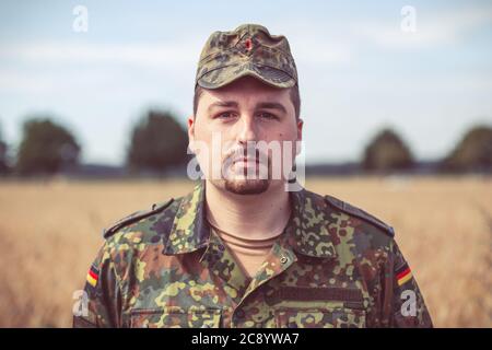 Ritratto di un soldato tedesco di fronte a un campo Foto Stock