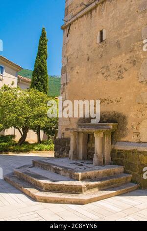 Un altare storico in pietra accanto al campanile della chiesa parrocchiale di San Vito nel villaggio di Podnanos, Valle di Vipava, comune di Vipava, Primorska, Slovenia Foto Stock