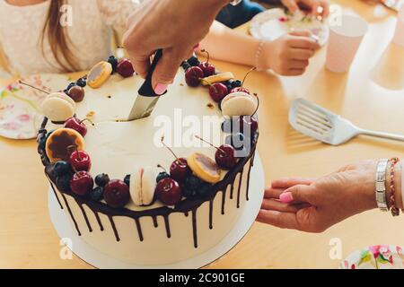 Bella torta di compleanno gustosa e regali su sfondo chiaro. Foto Stock